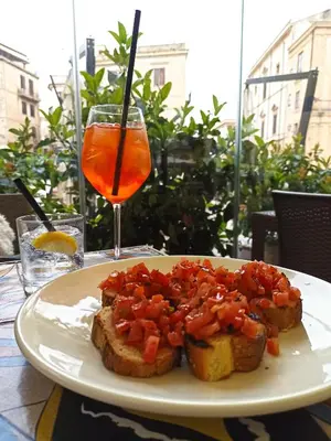 a plate of food on a table with a drink at Jacona 365 in Palermo