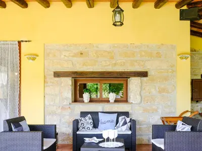 a living room with two chairs and a stone fireplace at Villa Carta Fashion by Interhome in Terrasini