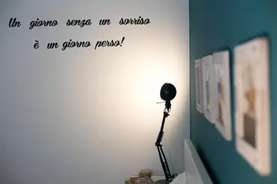 a lamp in a room with a quote on the wall at Nerissa suites&rooms in Terrasini