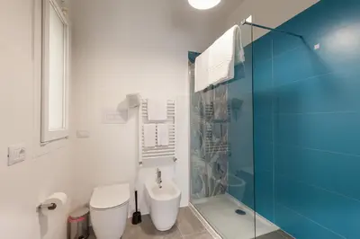 a bathroom with a toilet and a glass shower at Nerissa suites&rooms in Terrasini
