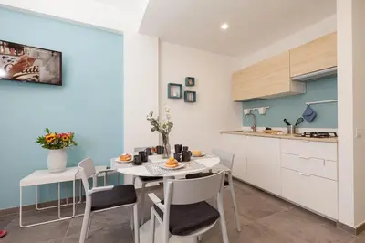 a kitchen and dining room with a table and chairs at Nerissa suites&rooms in Terrasini