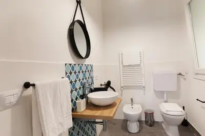 a bathroom with a sink and a toilet and a mirror at Nerissa suites&rooms in Terrasini