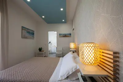 a bedroom with a large bed with a lamp on it at Nerissa suites&rooms in Terrasini