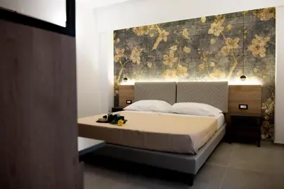 a bedroom with a bed and a wall with flowers at Case vacanza Puccini in Alcamo