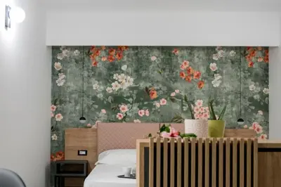 a bedroom with a flowery wallpaper on the wall at Case vacanza Puccini in Alcamo