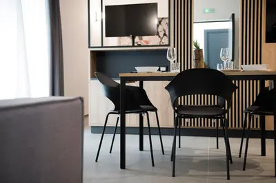 a dining room with black chairs and a table at Case vacanza Puccini in Alcamo