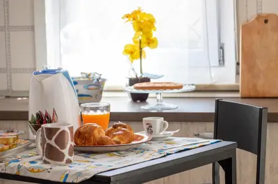 a table with a plate of croissants and orange juice at Butterfly House in Trappeto