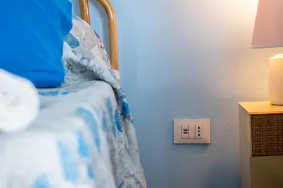 a bedroom with a bed with a lightswitch on the wall at Butterfly House in Trappeto