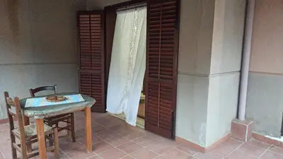 a table and chair in a room with a window at House Italia Holiday in Trabia