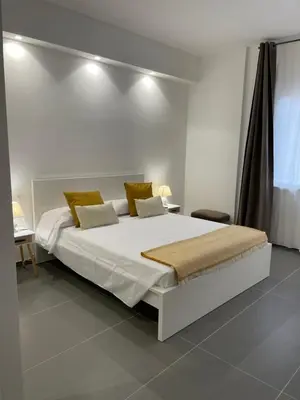 a bedroom with a large white bed with yellow pillows at Milu's Home in Palermo