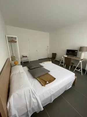a large white bed in a room with a desk at Milu's Home in Palermo