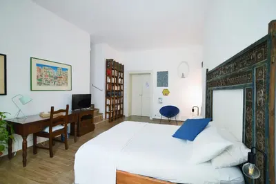 a bedroom with a bed and a desk and a computer at iFlat Palazzo Ragusi in Palermo