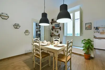 a kitchen and dining room with a table and chairs at iFlat Palazzo Ragusi in Palermo