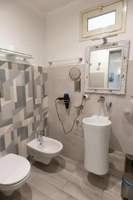 a bathroom with a toilet and a sink and a mirror at Federico 70 Smeraldo in Palermo
