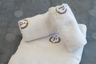 two white towels with smile faces embroidered on them at Federico 70 Rubino in Palermo