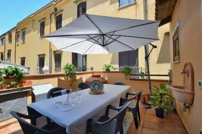 a white table with chairs and an umbrella on a balcony at iFlat Casa Tesò con terrazza sui tetti in Palermo