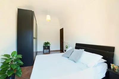 a bedroom with a white bed with a black headboard at iFlat Casa Tesò con terrazza sui tetti in Palermo