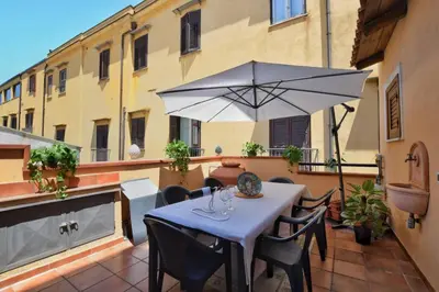a table and chairs with an umbrella on a balcony at iFlat Casa Tesò con terrazza sui tetti in Palermo