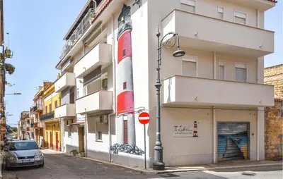 a building on a street with a car parked in front at 2 Bedroom Amazing Apartment In Trappeto in Trappeto