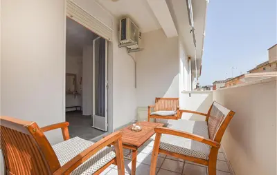 a small balcony with a wooden table and chairs at 2 Bedroom Amazing Apartment In Trappeto in Trappeto