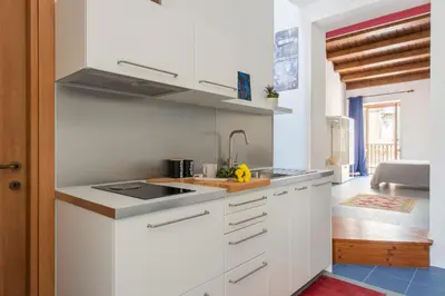 a white kitchen with a sink and a table at Vucciria Apartments by Wonderful Italy in Palermo