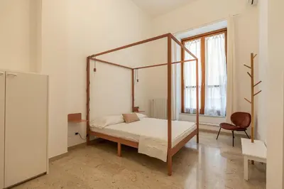 a kitchen with white walls and a table with black chairs at Vucciria Apartments by Wonderful Italy in Palermo
