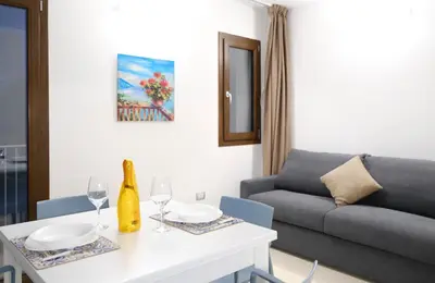 a living room with a couch and a table with wine glasses at SOL Y MAR Camere e Appartamenti in Castellammare del Golfo