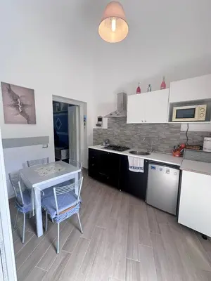 a kitchen with a table and a table and chairs at Luna Blu Apartment in Palermo