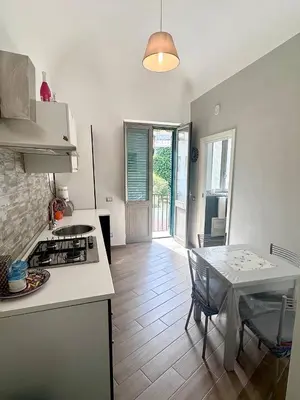 a kitchen and dining room with a table and a stove at Luna Blu Apartment in Palermo
