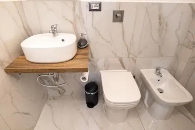 a white bathroom with a sink and a toilet at Sweet Home in Palermo