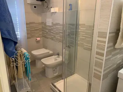 a bathroom with a toilet and a glass shower at CALA MARE in Palermo