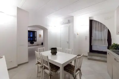 a white dining room with a white table and chairs at Monolocale Sant'Andrea in Palermo
