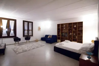 a bedroom with a bed and a blue couch at Monolocale Sant'Andrea in Palermo