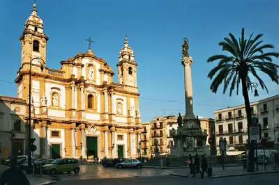 a large building with a palm tree in front of it at Monolocale Sant'Andrea in Palermo