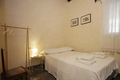 a bedroom with two beds with white sheets at Casa Miqvà - Rooms in shared apartment in Palermo