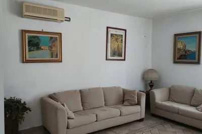 a living room with a couch and a fan at Casa del Grecale in Isola delle Femmine