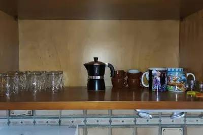 a counter with cups and mugs on a shelf at Casa del Grecale in Isola delle Femmine