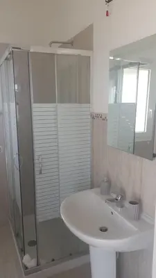 a white bathroom with a sink and a shower at Villa Serendipity Terrasini in Terrasini