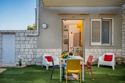 a patio with a table and chairs on the grass at Apt Perterrepermari a 2 Km Da Riserva Dello Zingaro in Scopello