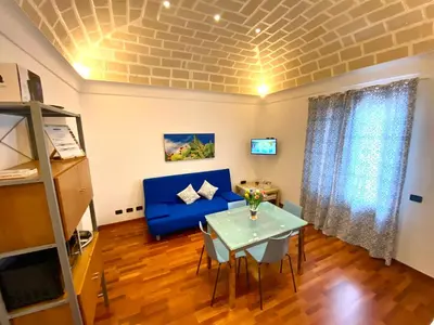 a living room with a blue couch and a table at Casa Mare in San Vito lo Capo