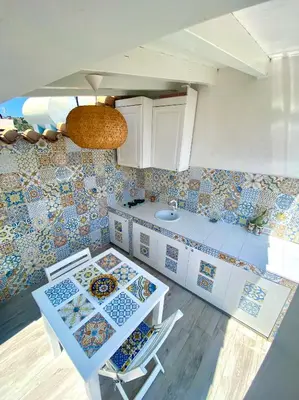a kitchen with blue and white tiles on the wall at Casa Sole in San Vito lo Capo