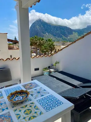 a balcony with a table and a view of a mountain at Casa Sole in San Vito lo Capo