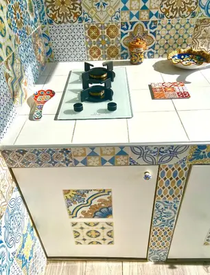 a kitchen with tiles on the wall and a stove at Casa Sole in San Vito lo Capo