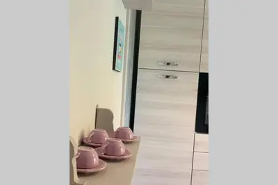 a row of pink dishes on a counter in a room at Casa vacanza - I Mulini con parcheggio gratuito incluso. in Monreale