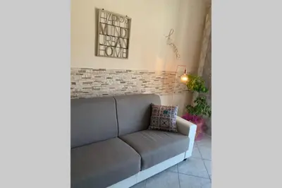a couch in a living room with a brick wall at Casa vacanza - I Mulini con parcheggio gratuito incluso. in Monreale