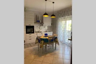 a kitchen with a table and a dining room at Casa vacanza - I Mulini con parcheggio gratuito incluso. in Monreale