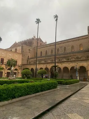 a large building with palm trees and a courtyard at Casa vacanza - I Mulini con parcheggio gratuito incluso. in Monreale