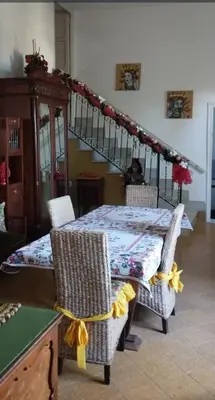 a dining room table with chairs and a staircase at Relais dei Mori Home Palermo in Casteldaccia