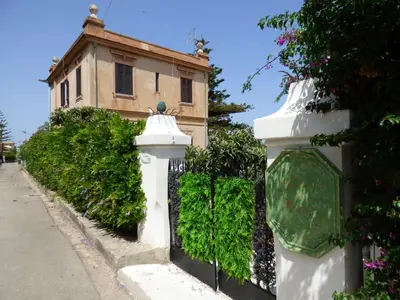 a white fence in front of a building at Relais dei Mori Home Palermo in Casteldaccia