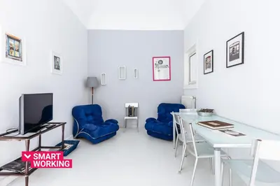 a living room with a table and blue chairs at Casa Dante with Balcony by Wonderful Italy in Palermo